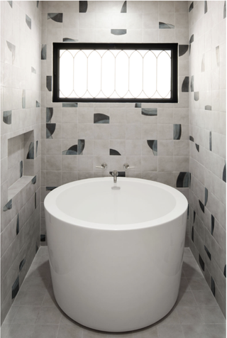 A white plunge bath with geometric tiles