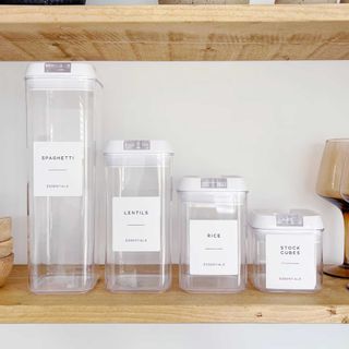 clear plastic food contianers with labels on kitchen shelves to show how to organise a kitchen with ease
