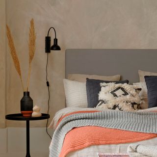 bedroom with cream colour texture wall and white bed and grey headboard