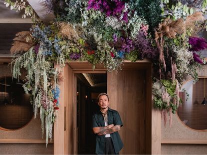 Satoshi Kawamoto beneath his plant installation at Sachi restaurant at the Pantechnicon in London