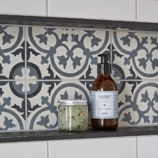 bathroom with printed tiled walls glass jar and bottle