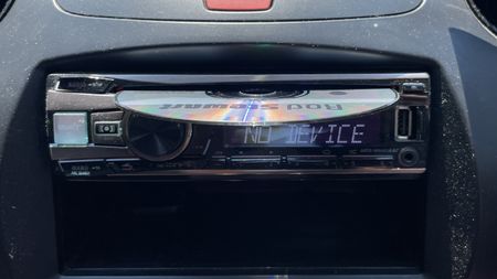 A car's CD player and burned CDs, on a hot day