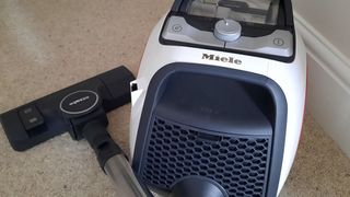 A Miele CX1 Boost PowerLine vacuum on a carpeted floor