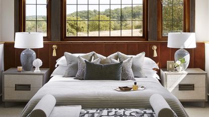 Bedroom furniture ideas with orange-brown velvet headboard, white sheets and grey bench