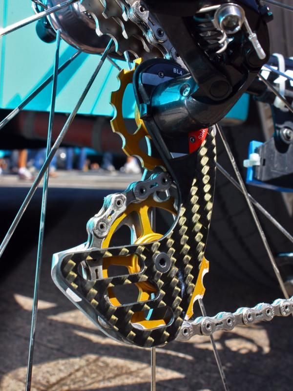 The custom derailleur cage attaches to the original cage's hacked-off stub.