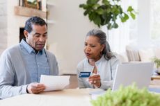 Husband helps review the credit card statement with wife