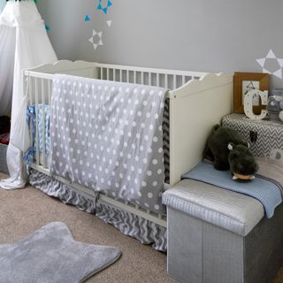 nursery with grey walls and white crib