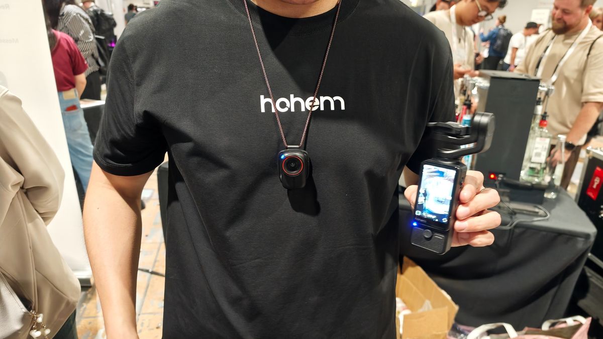 Man holding the Hohem Eyepic with camera unit attached to lanyard