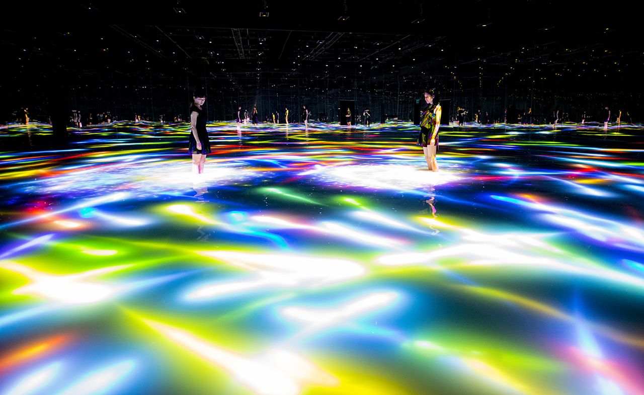 A floor filled with neon lighting and people standing ontop. 