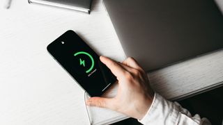 An iPhone being charged on a desk