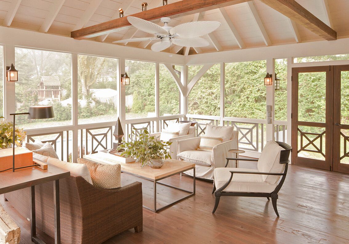 sunroom/porch with wooden flooring neutral sofas and chairs 