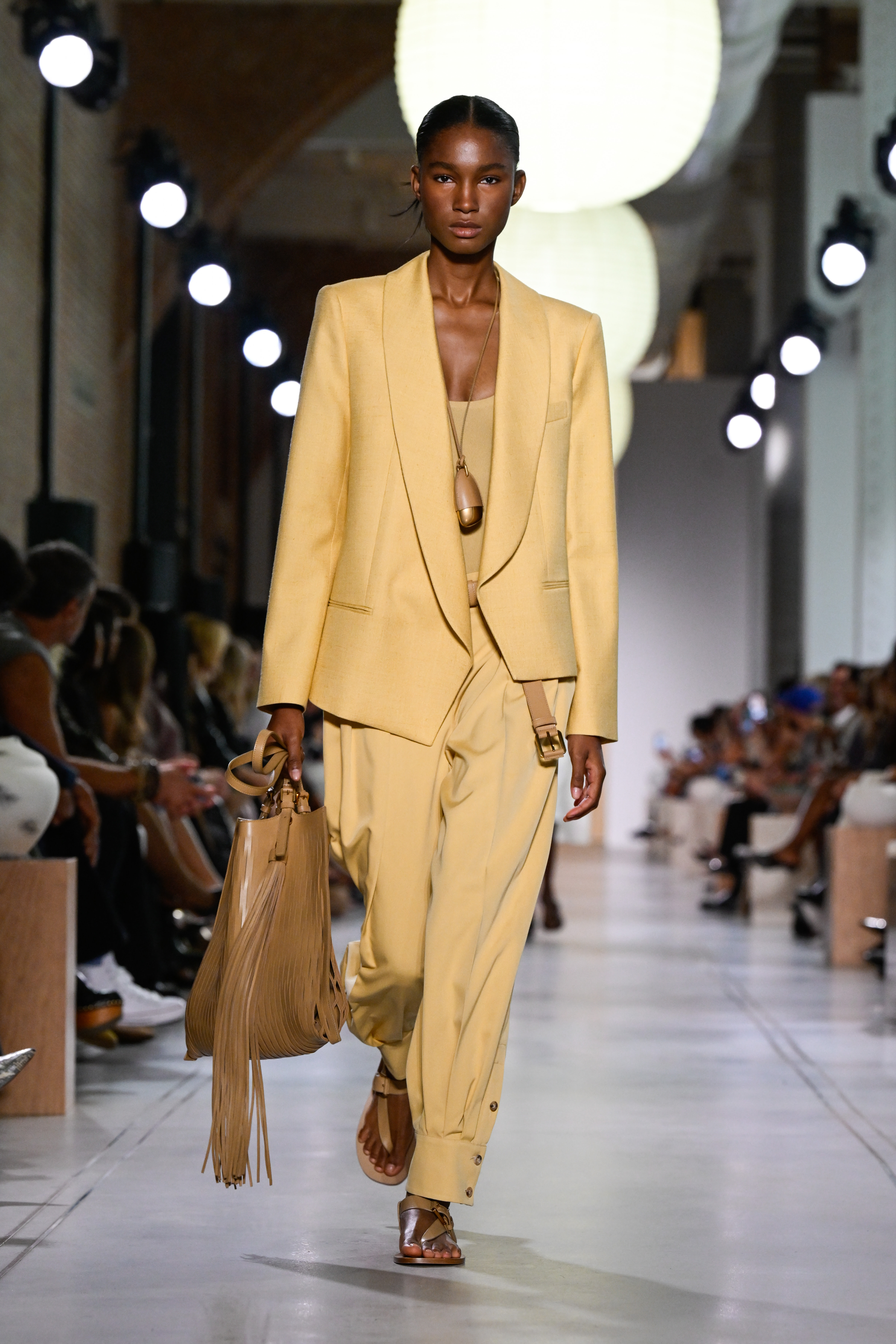 woman wearing a cord necklace and a yellow suit set