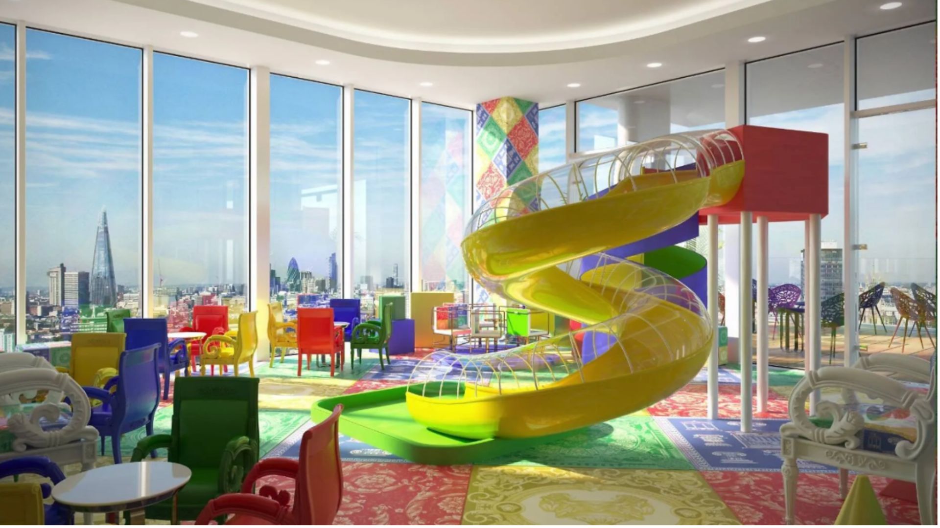 an image of the first playroom which has a big yellow tube slide in the middle of the room and a multicoloured mosiac style floor