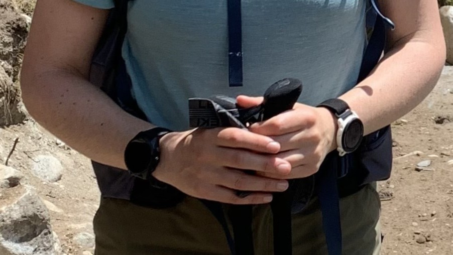 A close up of a hiker's hands with a GPS watch on each wrist