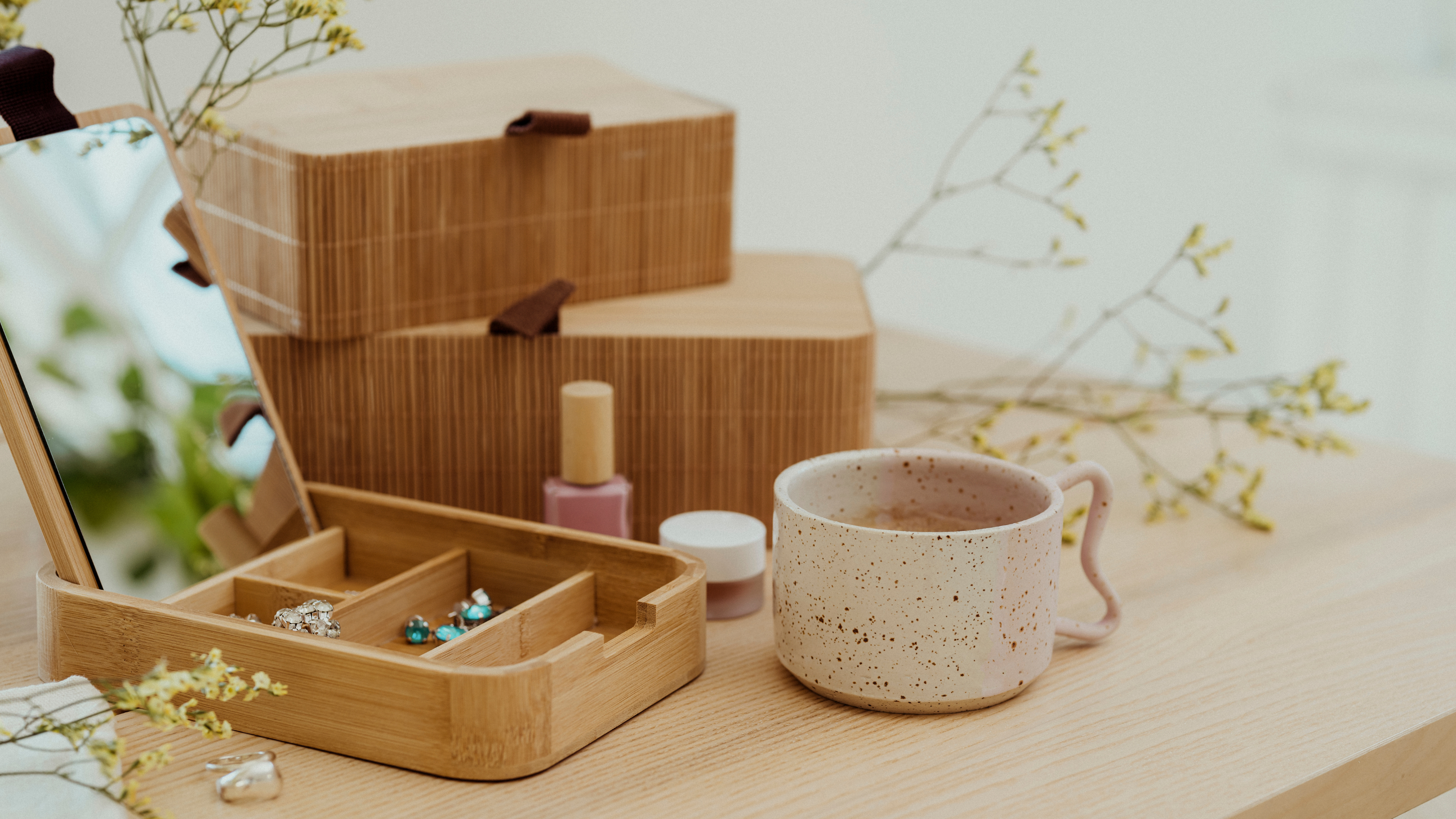 Wooden jewellery box and coffee mug on a wooden table.