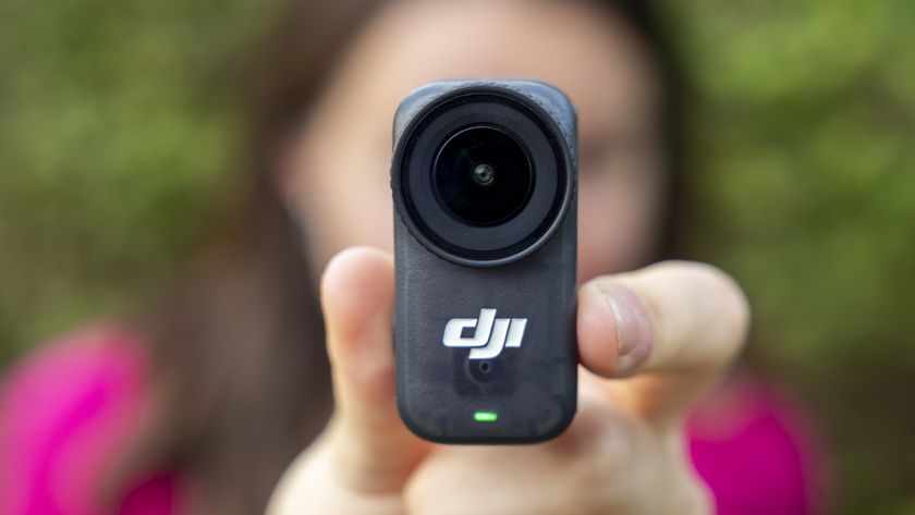 The DJI Osmo Nano camera held by a female photographer in a pink top