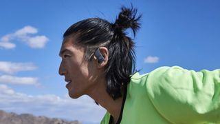 Man wearing JBL Endurance Peak 3 earbuds.