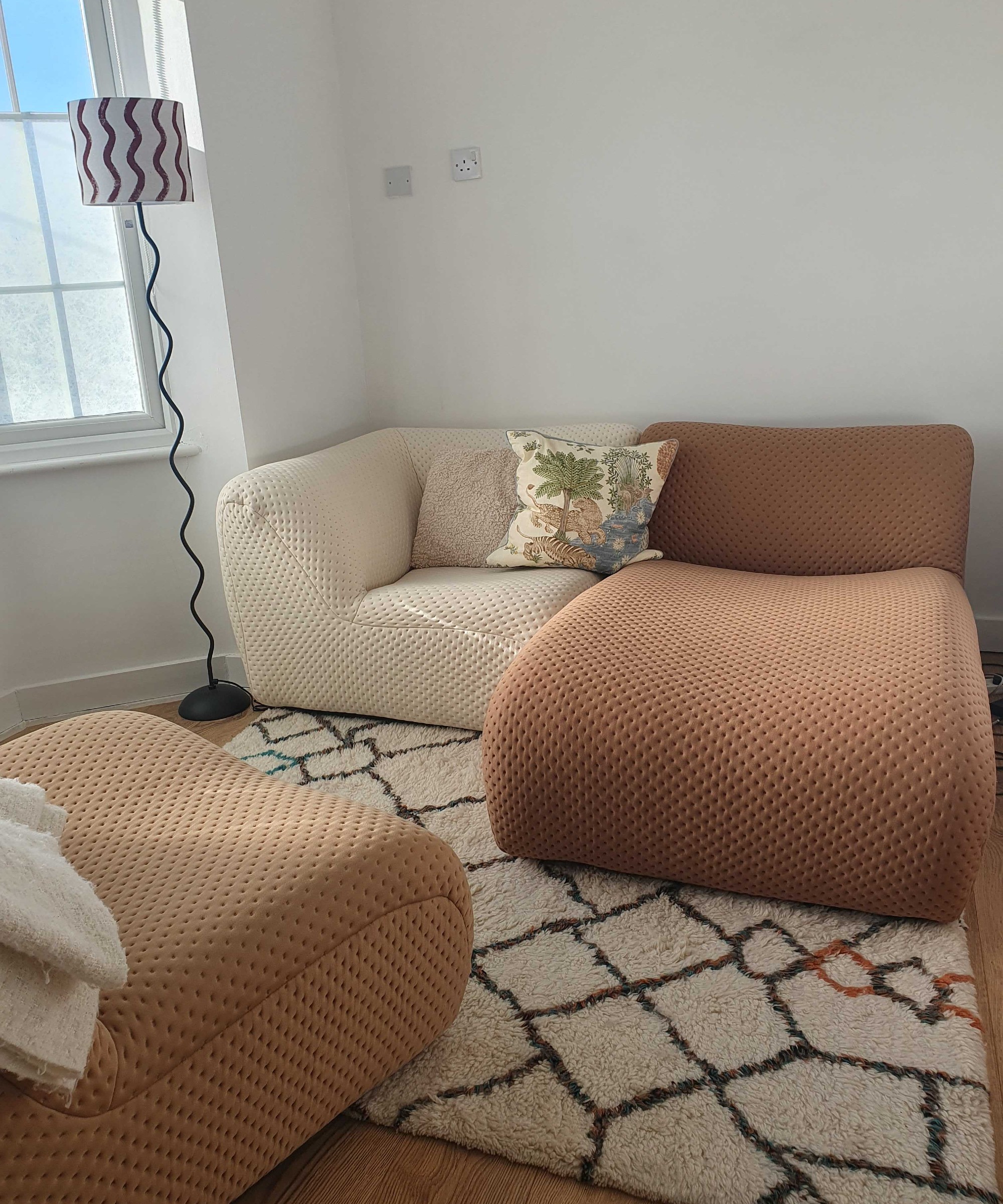 A small living area with the King Living 1977 modular sofa, a Berber-style rug and a wiggly floor lamp
