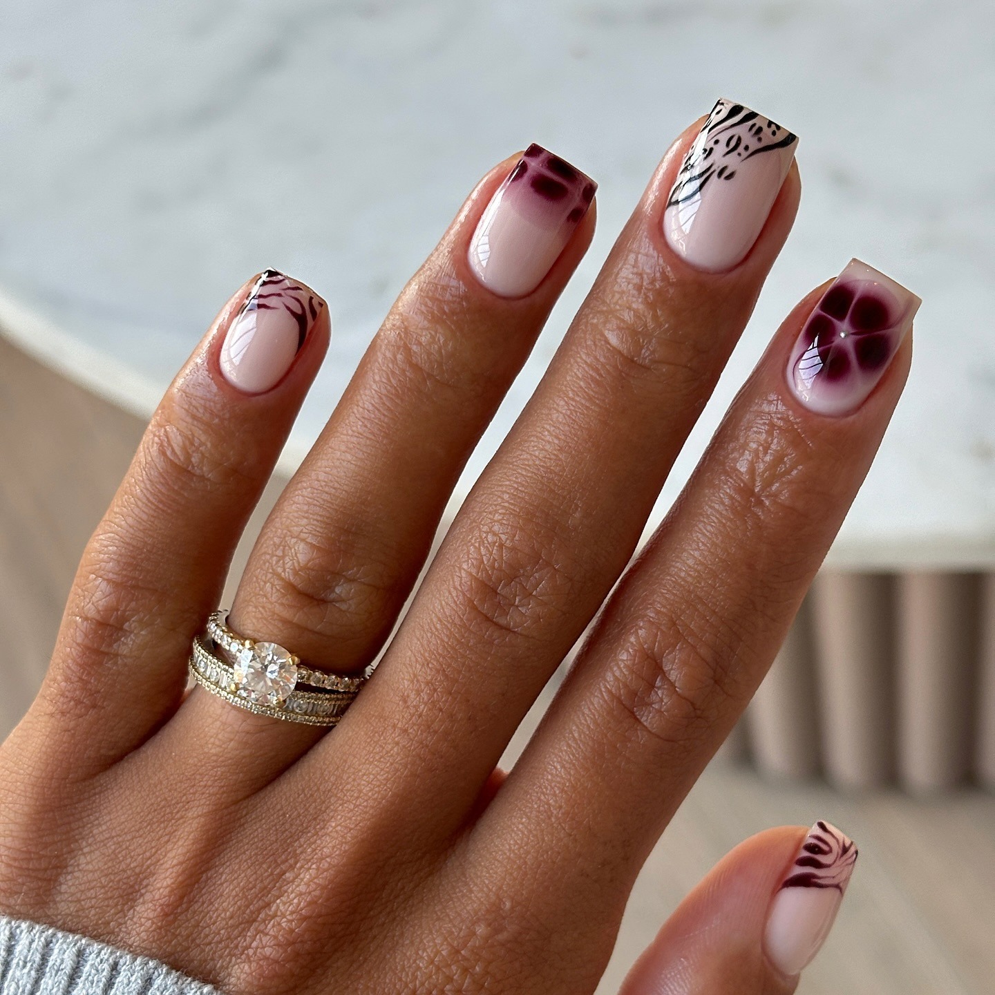 Mismatched nails with zebra and tiger striped French nail accents.