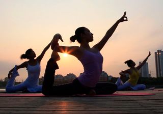 Women doing yoga at sunrise