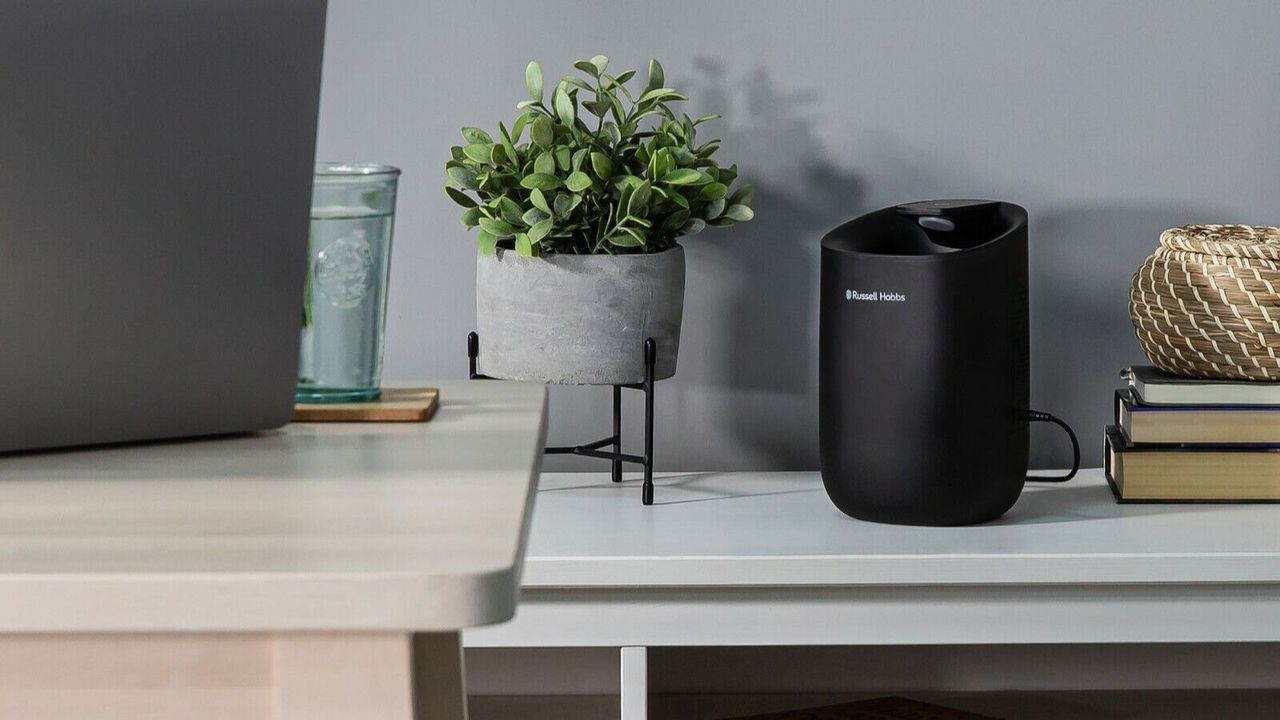 Russell Hobbs Fresh Air Pro Dehumidifier on a shelf next to a plant and some books