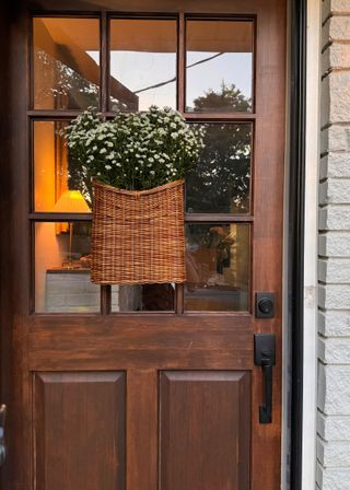 Daisies in a basket on a front door