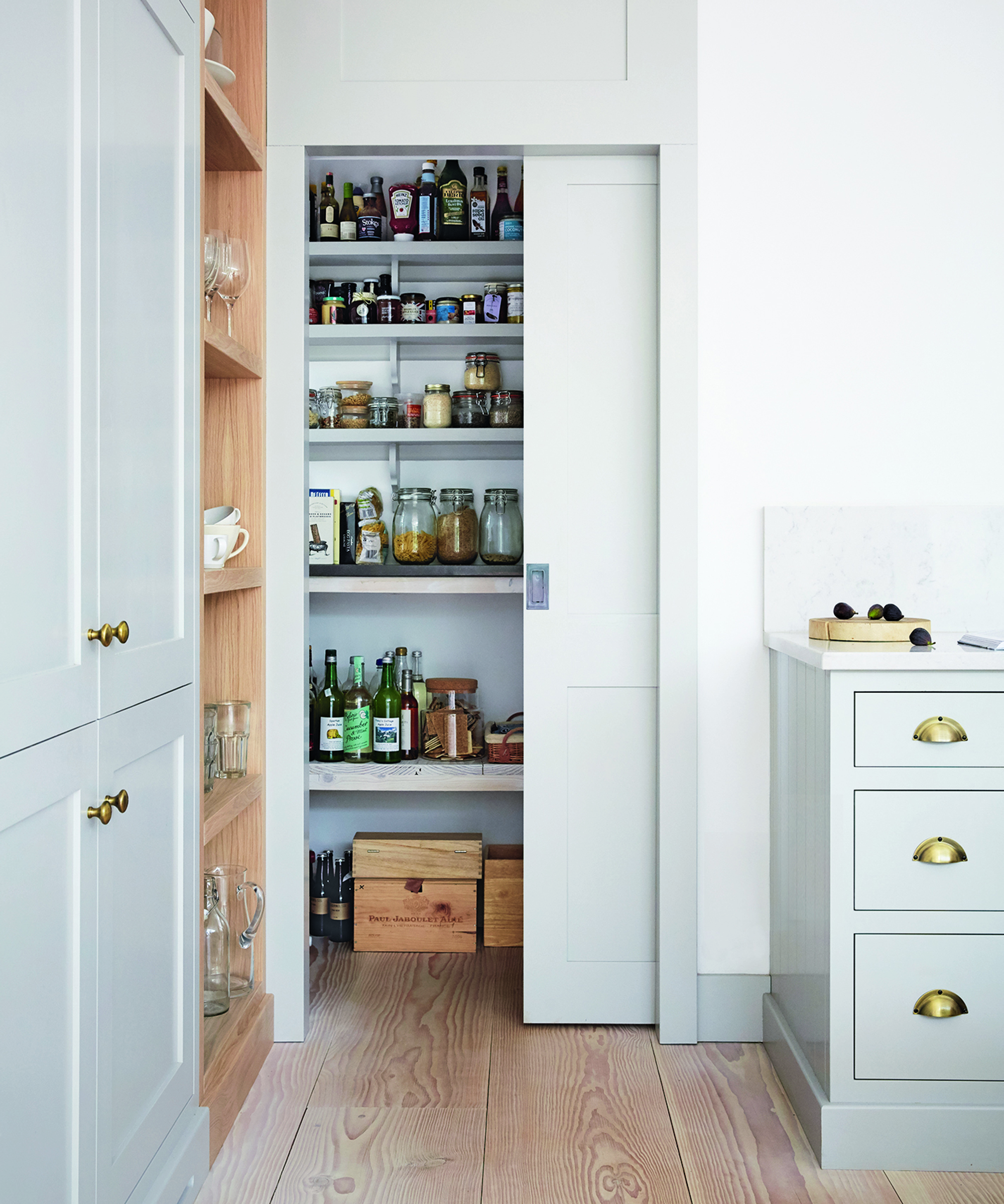 An example of small kitchen storage ideas showing a larder cupboard with a pocket door in duck egg blue