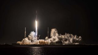 A SpaceX Falcon 9 Rocket Lifting Off From A Launchpad At Night