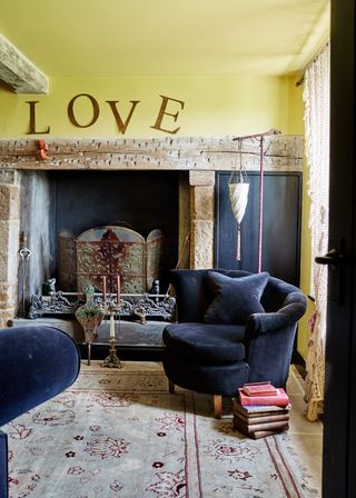 living room with yellow walls and black armchairs near fireplace
