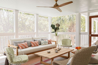 White sunroom with ceiling fan, contemporary white sofa and wicker furniture
