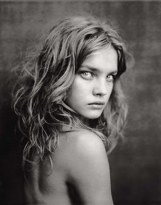 A young Natalia Vodianova stares at camera in photograph from Paolo Roversi Paris Palais Galliera Exhibition