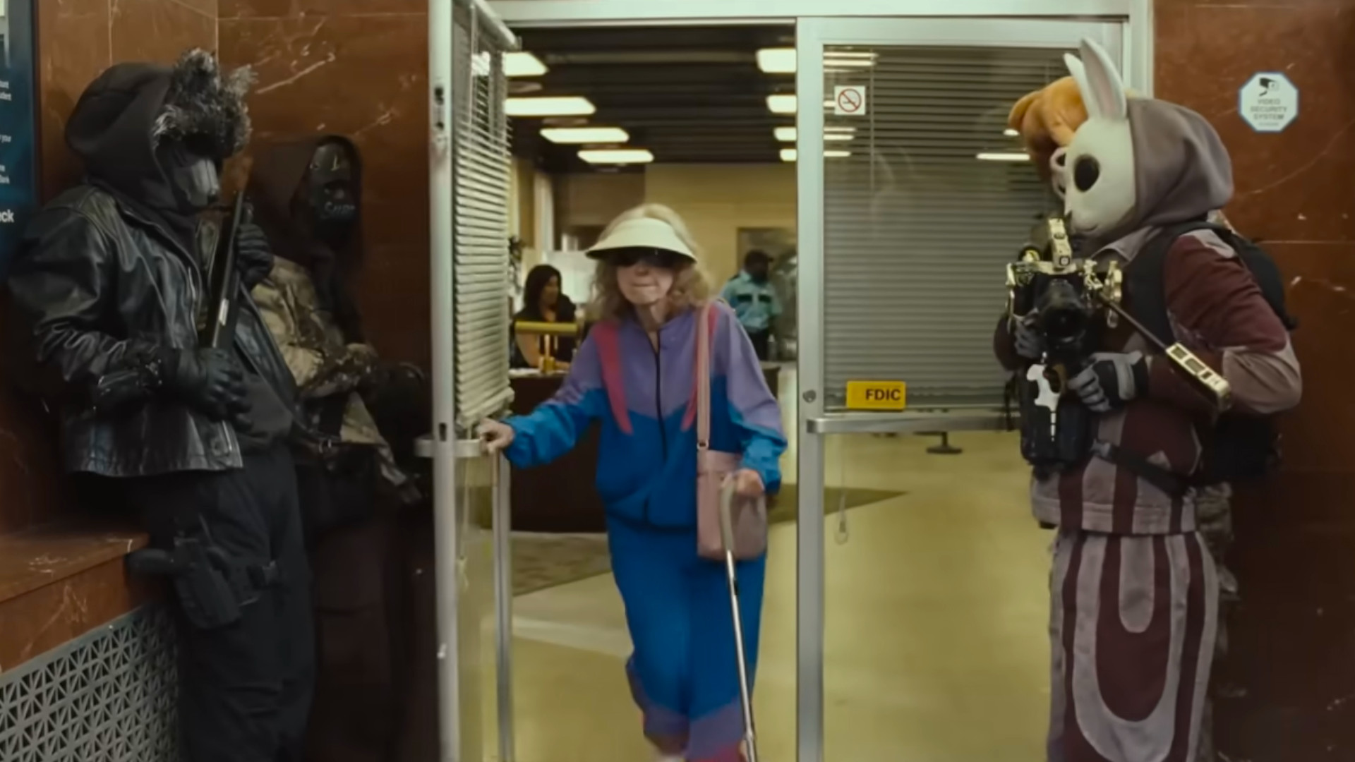 Four robbers wearing animal masks, letting a old lady leave a bank before they go and rob it in the trailer for the movie, How to Rob a Bank.