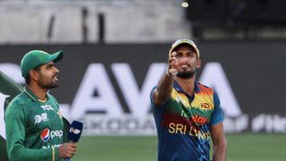 Sri Lanka's captain Dasun Shanaka (R) tosses a coin as Pakistan's captain Babar Azam watches before the start of Asia Cup Twenty20 cricket match in Asia Cup 2022