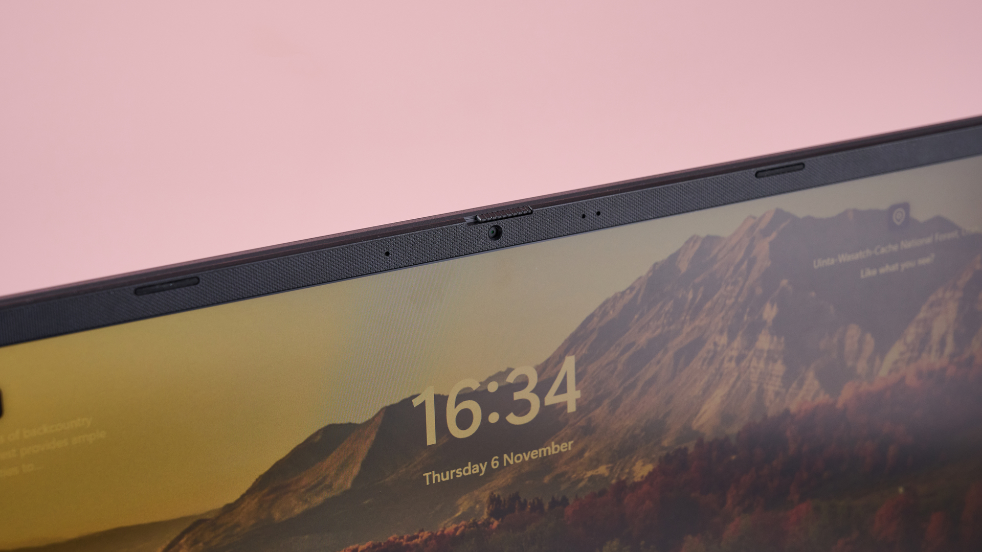Close-up of webcam on Asus V16 with pink wall in background