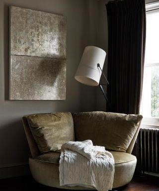 corner with armchair and lamp and artwork with olive green walls