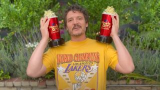 Pedro Pascal smiling and holding up two MTV Movie and TV Awards in 2023.