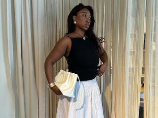 Nnenna Echem in a black tank top and white skirt.