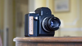 Nons SL660 instant camera on a mahogany table