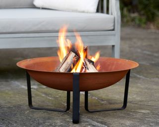 fire pit with burning logs and garden seat