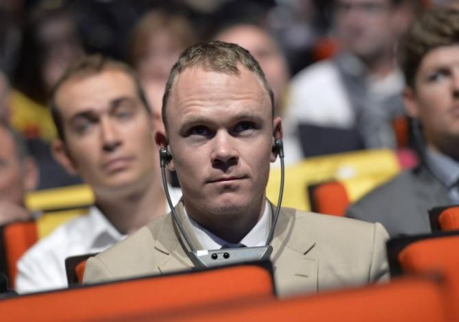 Chris Froome listens carefully as Christian Prudhomme unveils the 2014 Tour de France
