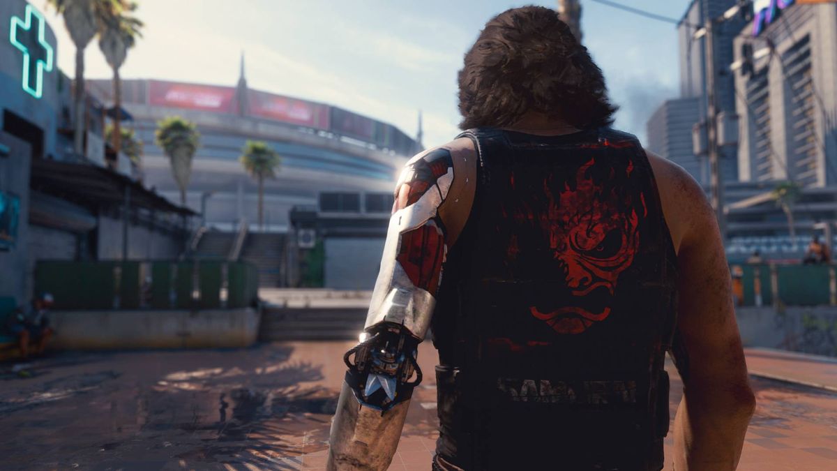 Johnny Silverhand (Keanu Reeves) walking away from the camera towards a stadium in Cyberpunk 2077.