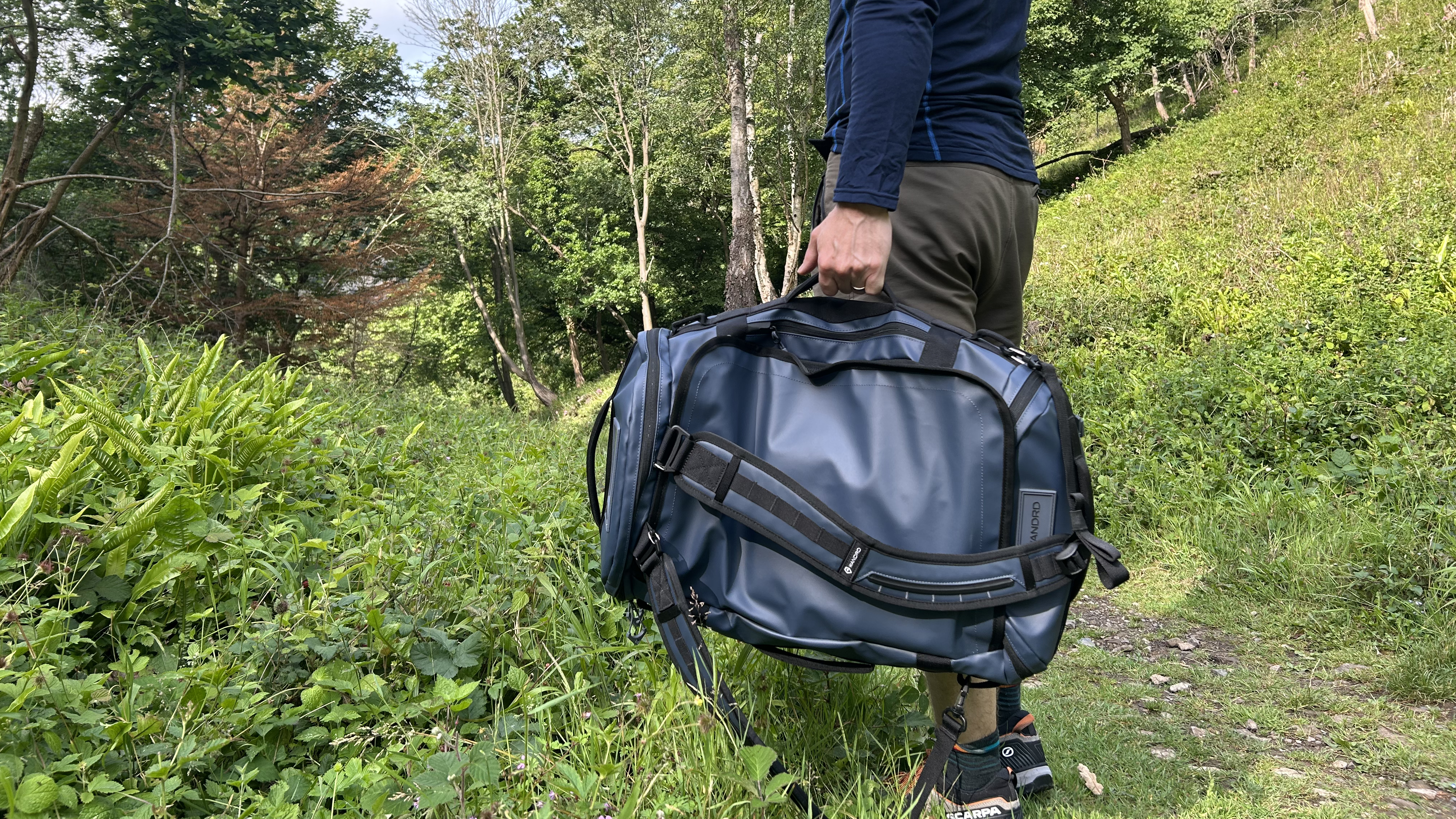 The Wandrd Carryall Duffel being hauled by its grab handles
