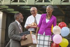 Older man retiring and celebrating with co-workers