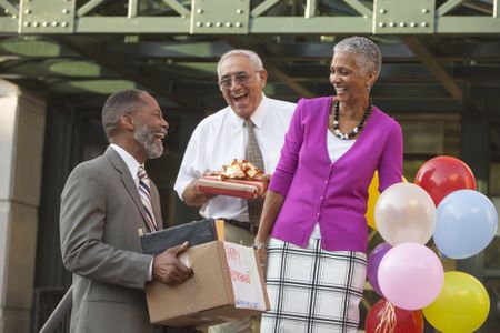 Older man retiring and celebrating with co-workers