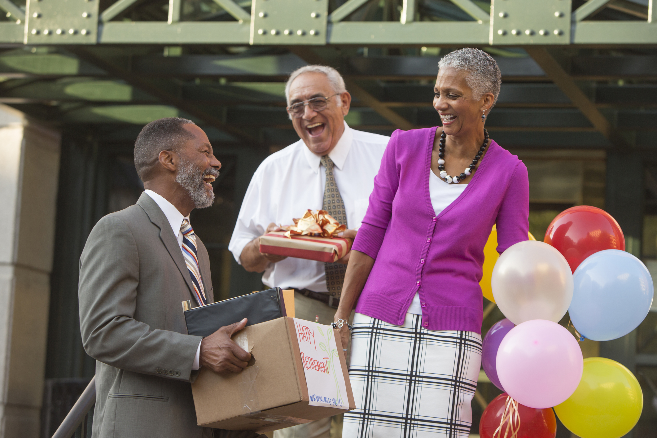 Older man retiring and celebrating with co-workers