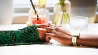 Two people holding hands over the table