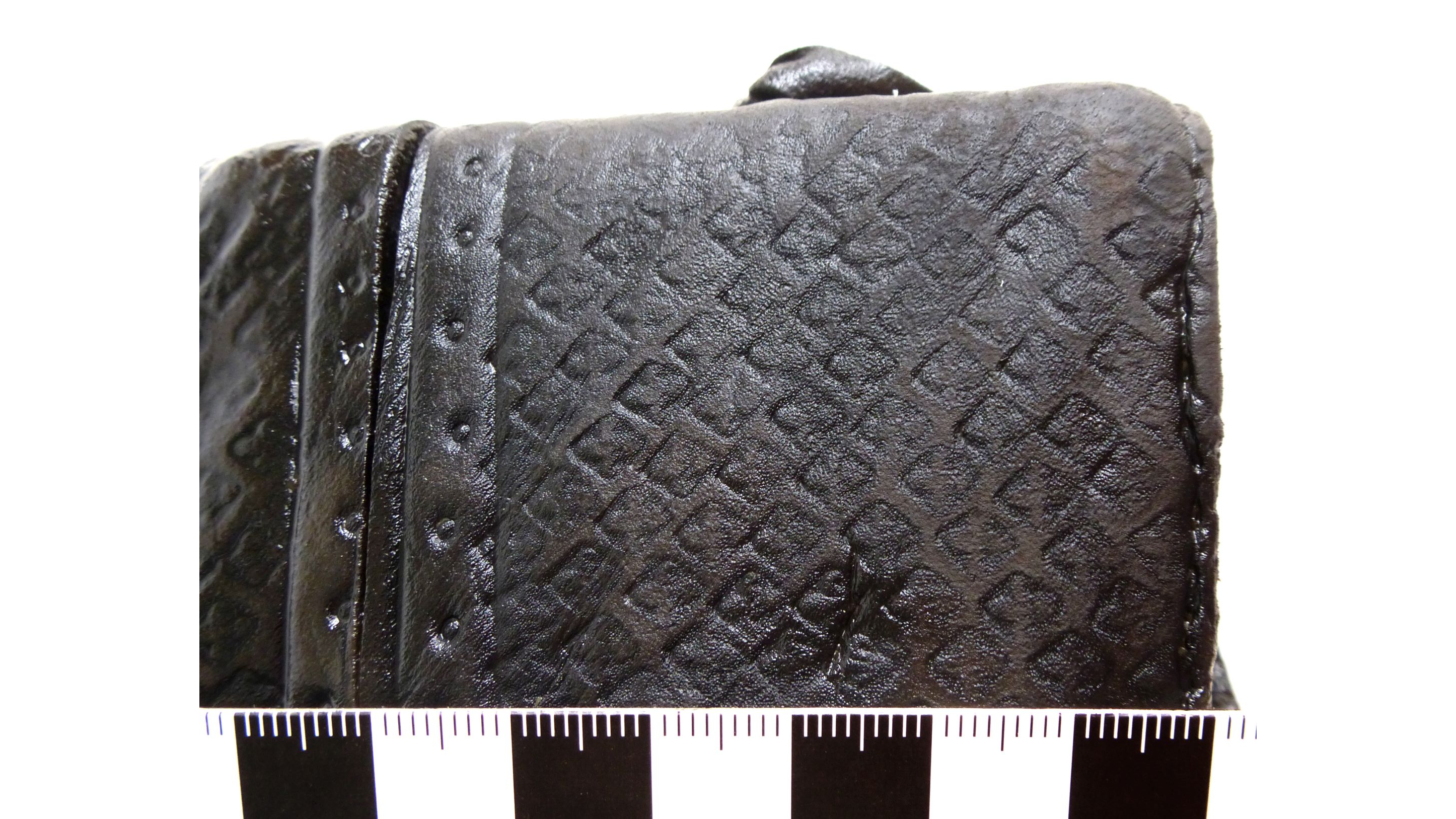 a leather bag with a fleur-de-lis stamped design