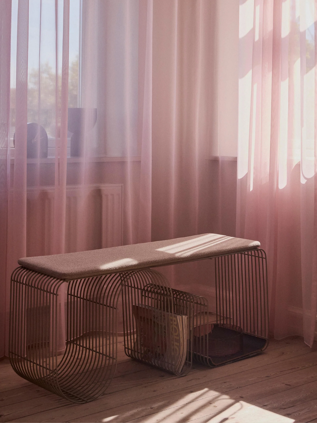 A curved matte greige metal bench from AYTM
