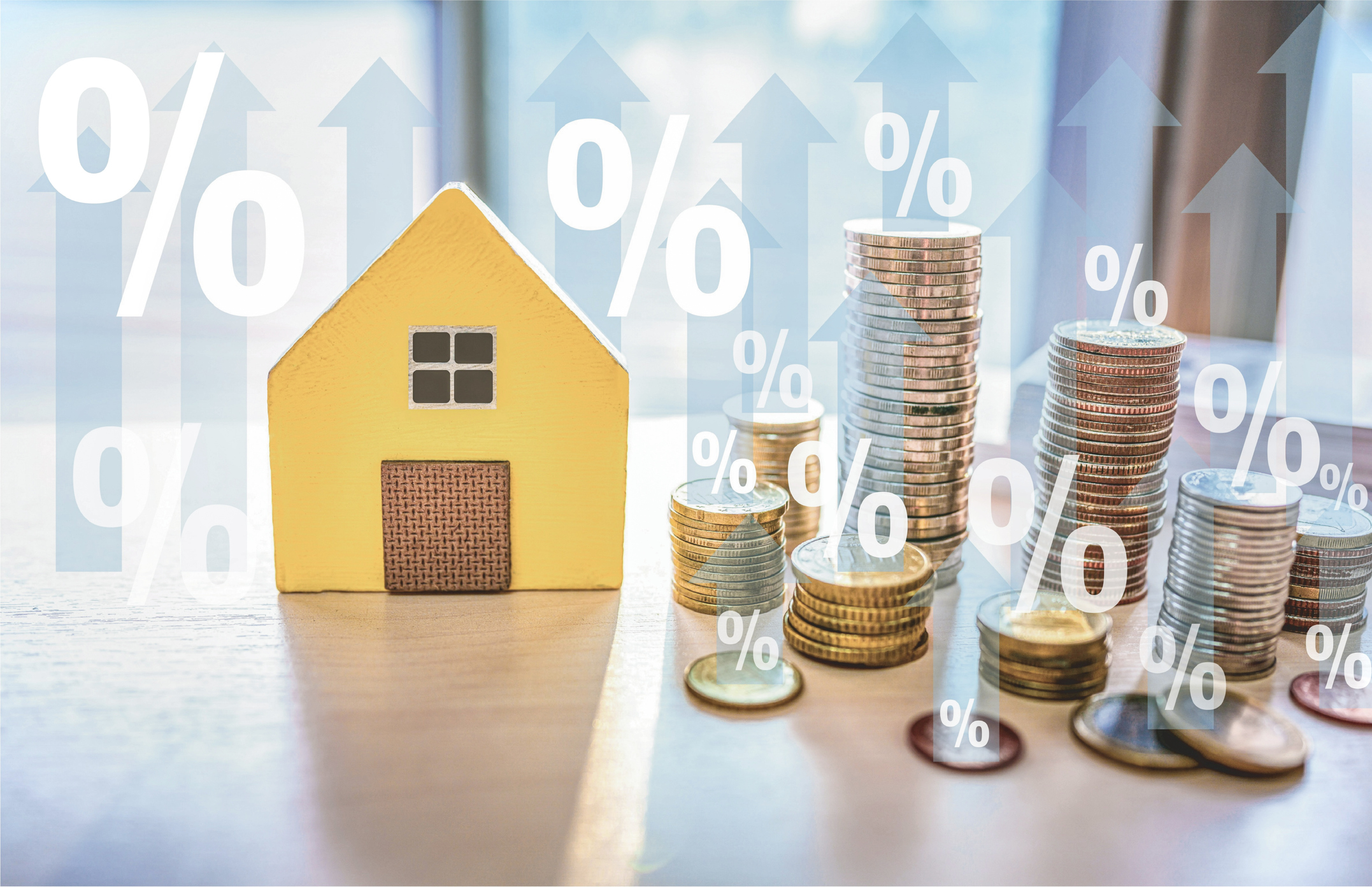 House next to piles of coins with percentage signs