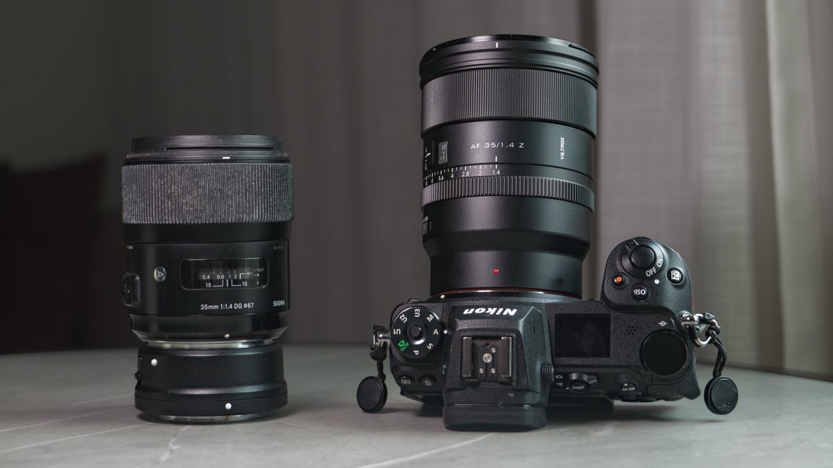 Viltrox AF 35mm F1.4 Pro lens attached to a Nikon mirrorless camera, alongside the Sigma 35mm f1/.4 DG Art lens with Nikon F to Z-mount adapter, on a white marble table